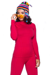 Women modelling EXTREME WOOL high-collared long-sleeve shirt and matching EXTREME WOOL raspberry leggings. Wearing a winter toque, and trendy yellow sunglasses.